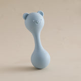 Blue bear-shaped rattle on a beige background