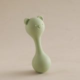 Green baby rattle toy on a beige background